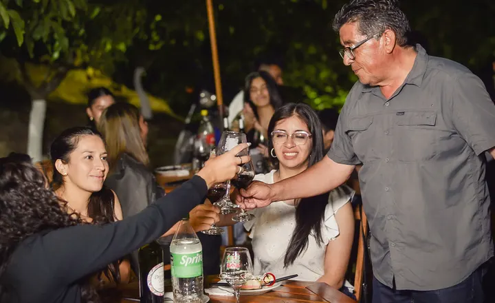 Brindis en una mesa larga durante una cena nocturna en la bodega